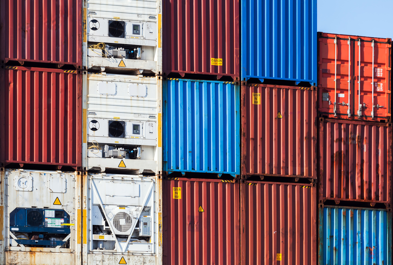 Metal Industrial cargo containers stacked in port | Rewind 92.7 & 102.3